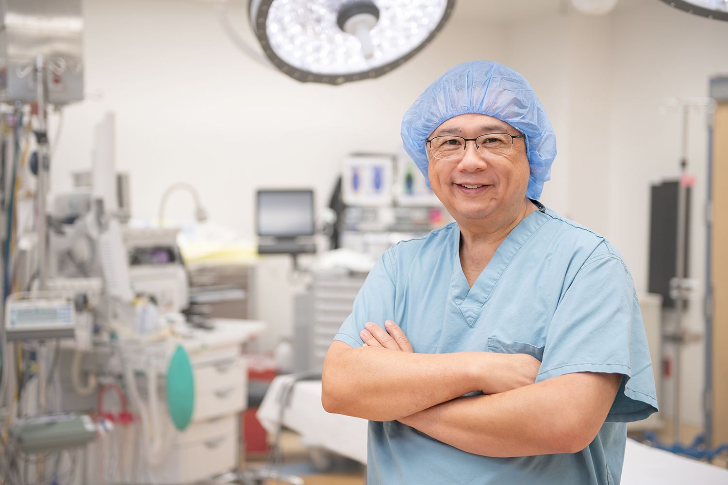 Physician smiling with arms crossed in surgical room