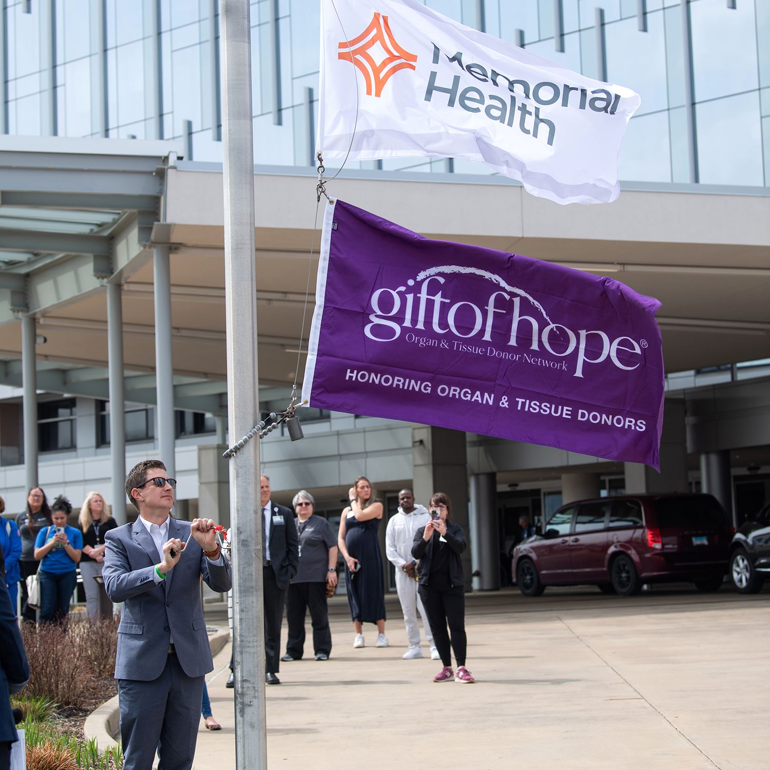 Person raising the gift of hope flag up a flagpole