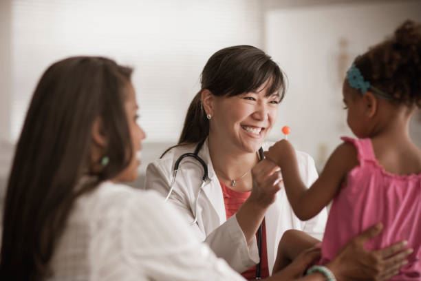 Physician gives lollipop to child at wellness checkup