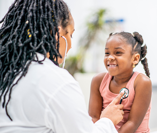 Doctor using a stethoscope on child during exam