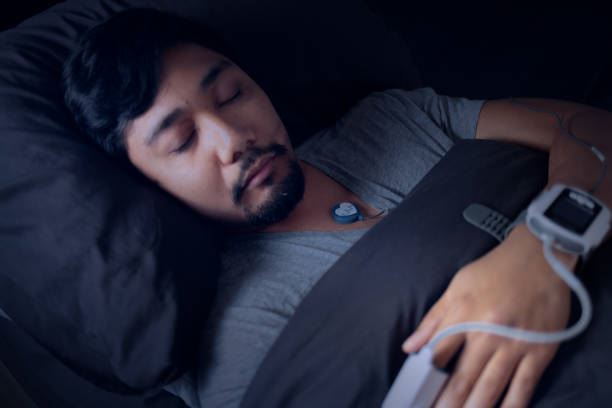 Man laying in bed taking part in a sleep study test
