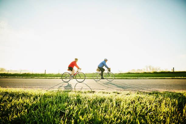 Two people riding bicycles down country road