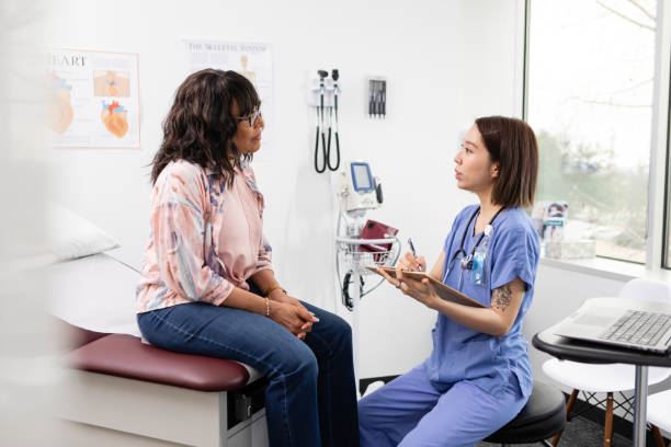 Nurse talking to patient seated in exam room