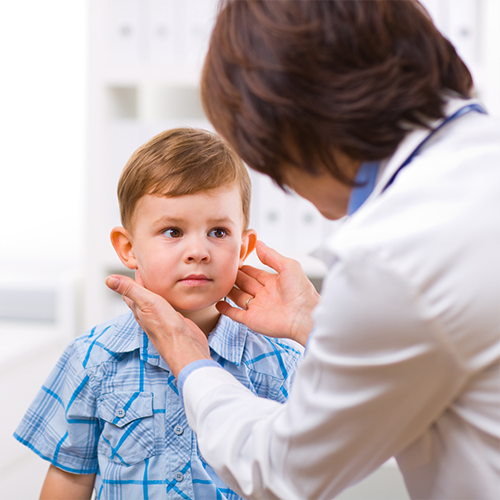 Doctor feeling child's neck as part of wellness exam