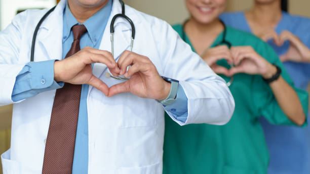 Healthcare workers making heart symbols with hands